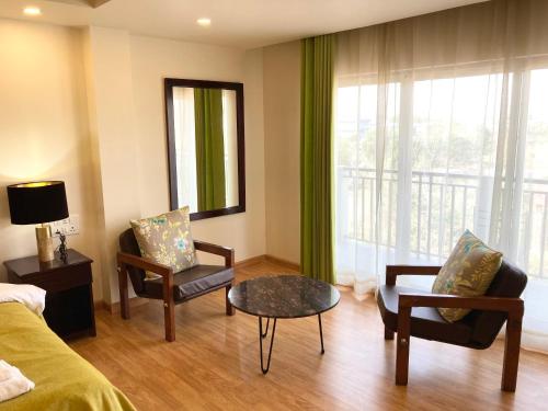 a room with a bed and a table and chairs at Shalom Farmhouse by the hillside in Imphal