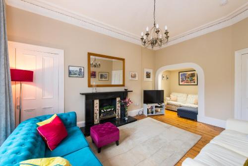 a living room with a blue couch and a fireplace at Arthur's Seat View in Edinburgh