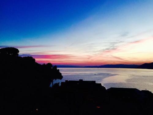 a view of a body of water at sunset at La Casa della Fiore in Camogli