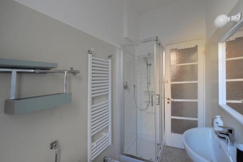 a white bathroom with a shower and a sink at La Casa della Fiore in Camogli