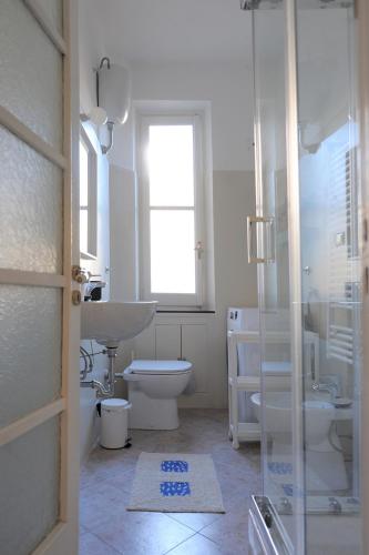 a white bathroom with a sink and a toilet at La Casa della Fiore in Camogli