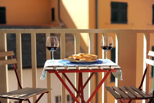a table with a plate of food and two glasses of wine at La Casa della Fiore in Camogli
