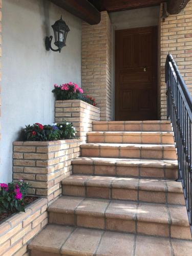 a front porch with stairs and a door with flowers at La casa di Pilar in Cotignola