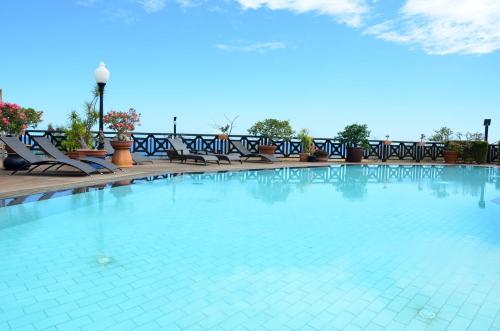 einen großen Pool mit Liegestühlen auf einer Terrasse in der Unterkunft Cases Couleurs in Saint-Leu