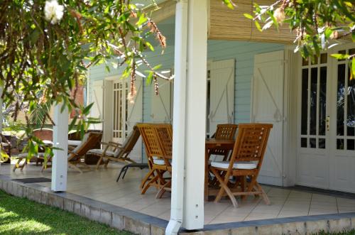 a porch with chairs and a table on a house at Cases Couleurs in Saint-Leu