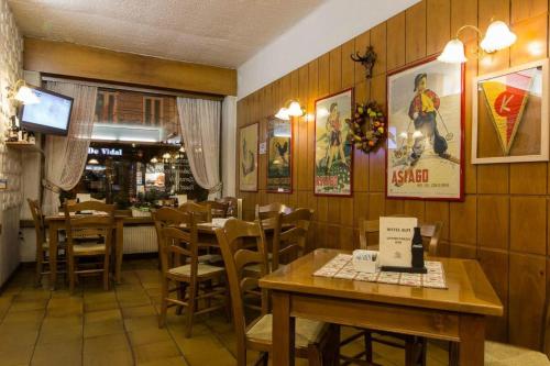 um restaurante com paredes e mesas e cadeiras de madeira em Hotel Alpi - Asiago em Asiago