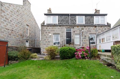 an old stone house with a green yard at Aberdeen Quiet City Apartment, Ferryhill in Aberdeen