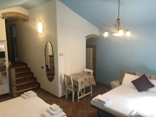 a room with two beds and a table and a mirror at La casa di Pilar in Cotignola