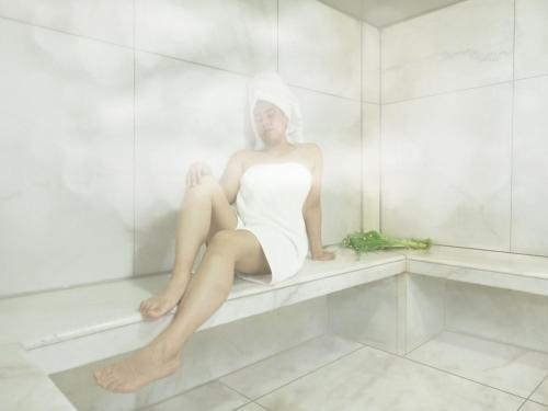 a woman in a white dress sitting in a bathtub at Inkari Apart Hotel in Lima