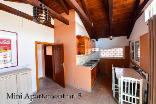 a kitchen with wooden ceilings and a dining room at Kultura Hostel in Shkodër