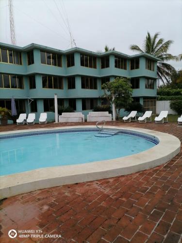a hotel with a swimming pool in front of a building at Hotel El Doral in Monte Gordo