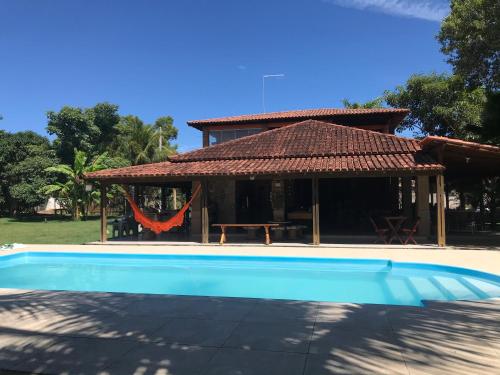 a house with a swimming pool in front of a house at Pousada Nativo's in Nova Almeida