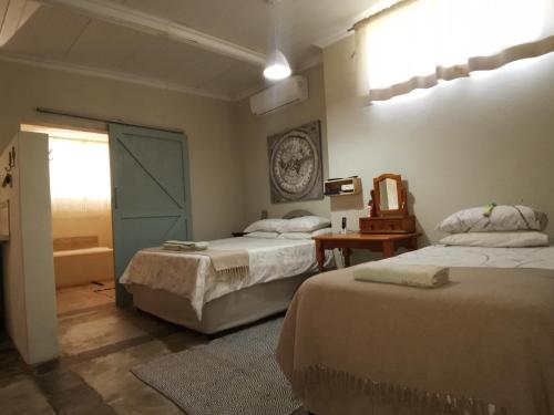 a bedroom with two beds and a mirror on the wall at MacNut Bed and Breakfast in Nelspruit