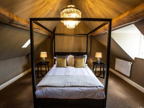 a bedroom with a canopy bed with a chandelier at The Gaol in Bewdley