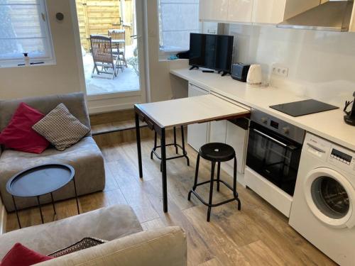 a living room with a kitchen with a table and a washing machine at Villas Chapu in Fontainebleau