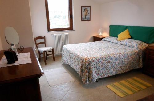 Chiassa SuperioreにあるI 3 Cipressiのベッドルーム1室(ベッド1台、テーブル、椅子付)