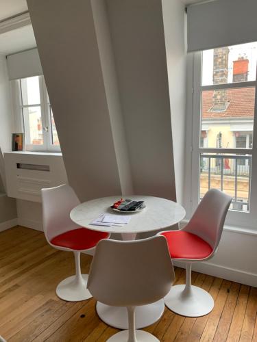 einen weißen Tisch und Stühle in einem Zimmer mit Fenster in der Unterkunft Celect'In Lyon Suites climatisées SkyView in Lyon