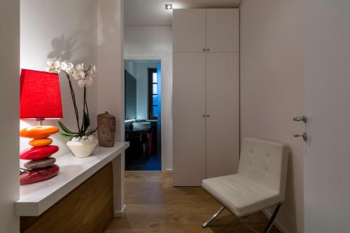 ein Wohnzimmer mit einer roten Lampe und einem weißen Stuhl in der Unterkunft Apartment Acero Rosso in Riccò del Golfo di Spezia