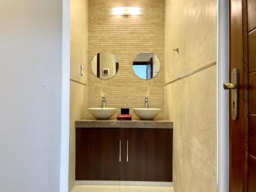 a bathroom with two sinks and a mirror at Sucre Center in Sucre