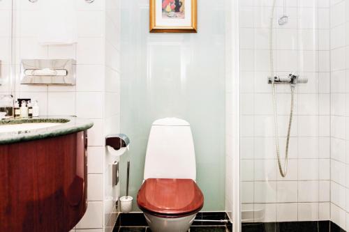 a bathroom with a toilet with a red seat at Elite Plaza Hotel in Gothenburg