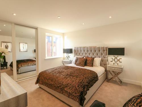 1 dormitorio con 1 cama extragrande y espejo en Harbourside Haven Apartment 3 en Weymouth