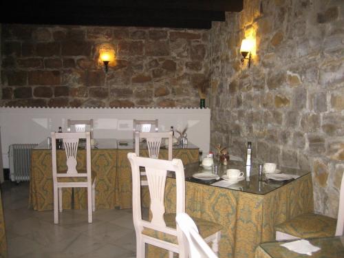 a kitchen with a counter and two white chairs at Palacio de la Rambla in Úbeda