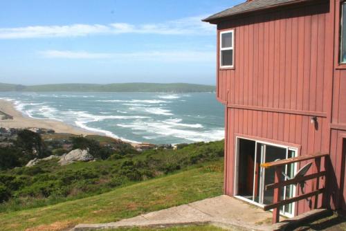a red building with a view of the ocean at Abalone Alcove! Hot Tub! Pool Table! AMAZING VIEWS! Fast WiFi!! Dog Friendly! in Dillon Beach