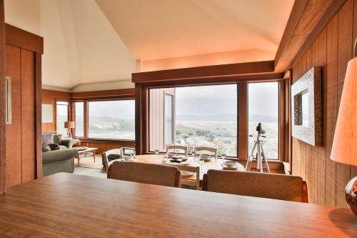 a dining room with a table and a large window at Abalone Alcove! Hot Tub! Pool Table! AMAZING VIEWS! Fast WiFi!! Dog Friendly! in Dillon Beach