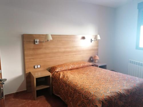 a bedroom with a bed and a wooden headboard at Casa de la abuela digit@l in Martín del Río