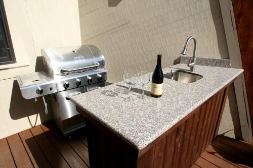 a bottle of wine sitting on a counter next to a sink at Beach Nest! Hot Tub! Sauna! BBQ Grill! AMAZING VIEWS!! Romantic Getaway! Dog Friendly!! in Dillon Beach