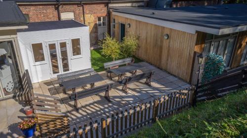 a patio with two benches and a house at Harper's Steakhouse with Rooms, Haslemere in Haslemere