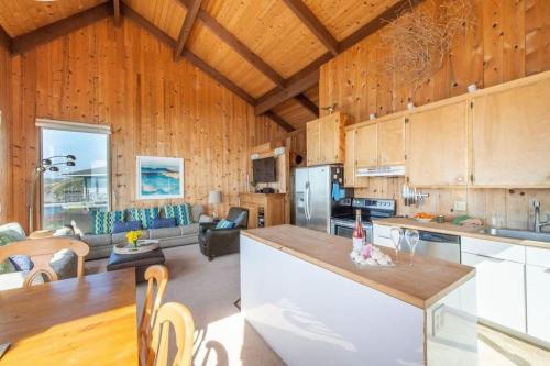 a large kitchen and living room with wooden walls at Breaking Waves! On the Bluff! AMAZING VIEWS!! BBQ! Fast WiFi! Walk to Beach!!! in Dillon Beach