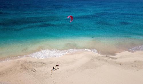 a person is flying a kite on the beach at Agua Hotels Sal Vila Verde in Santa Maria