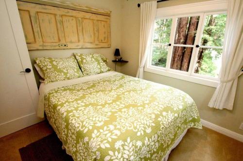 una camera da letto con un letto e una finestra di Little Red House! Redwoods! Hot Tub! BBQ! Fast WiFi!! Multiple Decks!! Near Golf Course!! Dog Friendly! a Guerneville