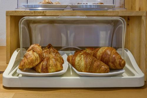 two trays of croissants and bread in a refrigerator at Hotel Vittoria in Viareggio