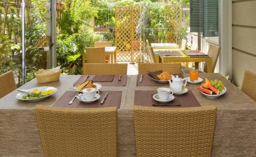 a table with plates of food and cups on it at Hotel Vittoria in Viareggio