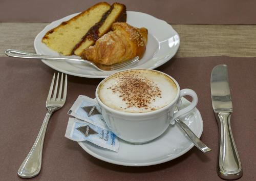 a cup of coffee and a plate of bread at Hotel Vittoria in Viareggio