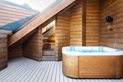 a wooden house with a hot tub on a deck at El Lodge, Ski & Spa in Sierra Nevada