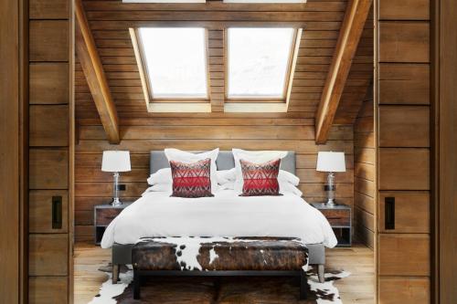 a bedroom with a bed and two windows at El Lodge, Ski & Spa in Sierra Nevada