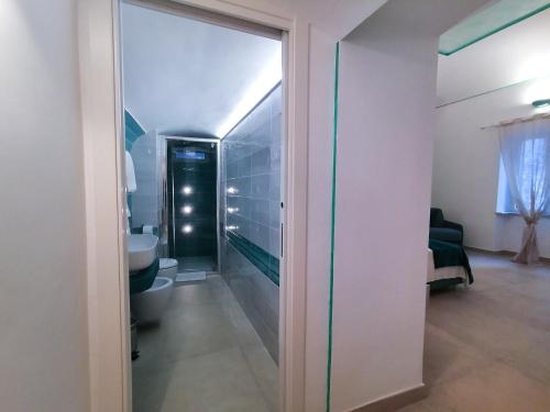 ein Badezimmer mit einem WC und einer Glastür in der Unterkunft Atrani Rooms in Atrani