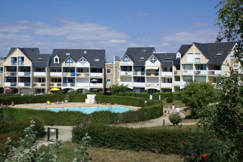 un groupe d'immeubles d'appartements avec une piscine dans l'établissement REF 104 Appartement T3 pour cinq personnes résidence avec piscine Port Crouesty ARZON, à Arzon