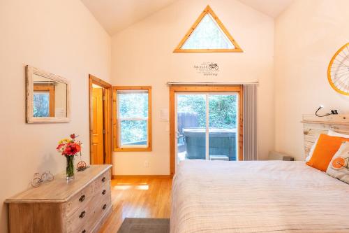 a bedroom with a large bed and a window at Vino Velo Retreat! Redwoods! Hot Tub!! Fire Table!! BBQ!! Game Room!! Fast WiFi!! Dog Friendly!! in Guerneville