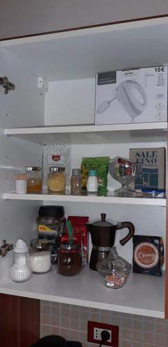 a kitchen shelf filled with lots of kitchen items at Apartments & Rooms Villa Adamović in Umag