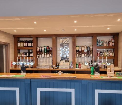 a bar with blue cabinets and bottles of alcohol at The Aston Inn in Birmingham