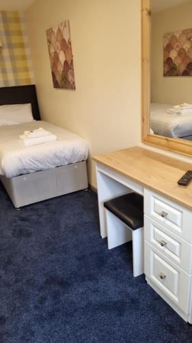 a room with two beds and a desk and a mirror at The Aston Inn in Birmingham