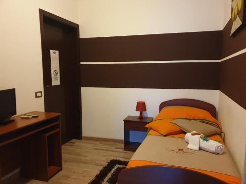 a bedroom with a bed and a desk and a television at Antica Vittoria in Vittoria