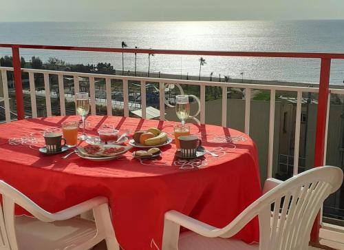 una mesa con copas de vino y comida en el balcón en terraza al mar, en Pineda de Mar