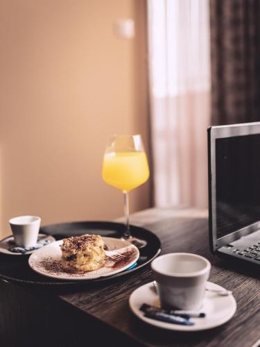a table with a plate of food and a glass of orange juice at Plaza Hotel Plovdiv - Free Parking in Plovdiv