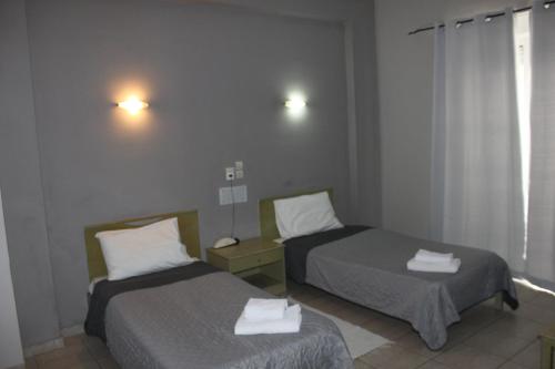 a room with two beds with towels on them at Hotel Avra in Volos