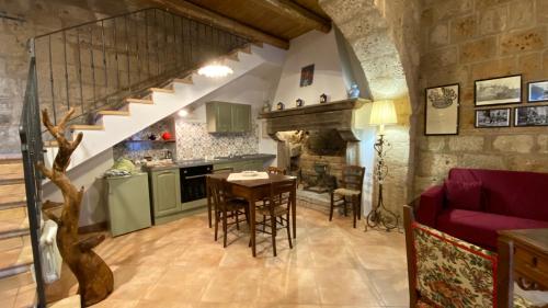 a kitchen and living room with a table and a staircase at Il Vento e la Ginestra in Bagnoregio
